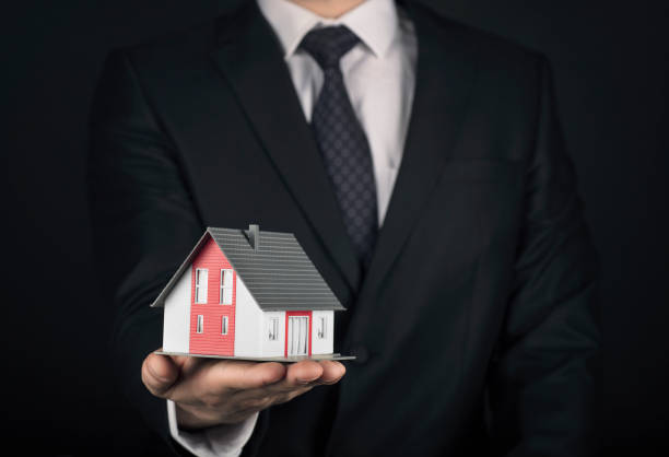 istock Business man holding model house 950295252