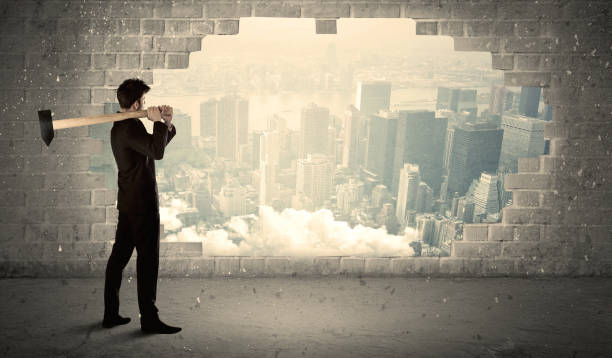 istock Business man hitting wall with hammer on city view 950295366