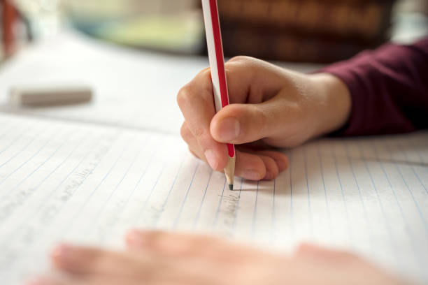 ragazzo che fa il suo lavoro scolastico o compiti a casa - scrivere foto e immagini stock