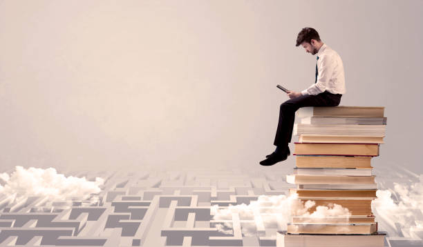 istock Man with tablet sitting on books 950296218