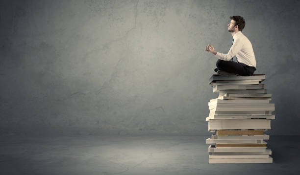 istock Stylish male seated on books 950296370