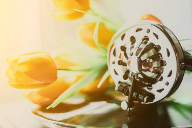 A bouquet of yellow tulips in vase in the interior of a retro room. Retro interior with bouquet of tulips old phone and suitcase.