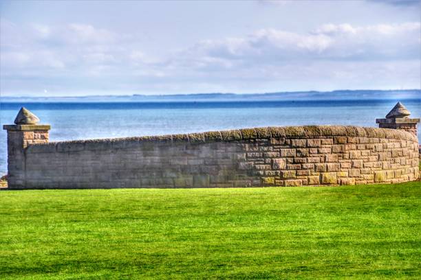 An striking set of 8 abstract images of the seafront at Carnoustie, on the Firth of Tay near the World Class Competition Golf Links Course, often the home of The Open Championship. The images, all taken in late afternoon spring sunshine, depict unusual angles, close-ups of sea walls and boulders, barriers and sculpted sheltering walls along the layout of this otherwise unremarkable promenade along the seafront at high tide. An unusually blue North Sea and dramatic cloudscapes add to the atmosphere of these shots which depict a different side to the calm, conservative famous golfing town.