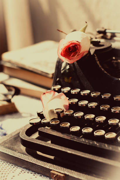istock Vintage typewriter with pink rose , old books on table. 950313722