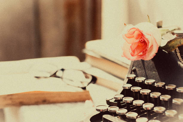vintage typewriter with pink rose , old books on table. - typewriter sepia toned old nostalgia imagens e fotografias de stock