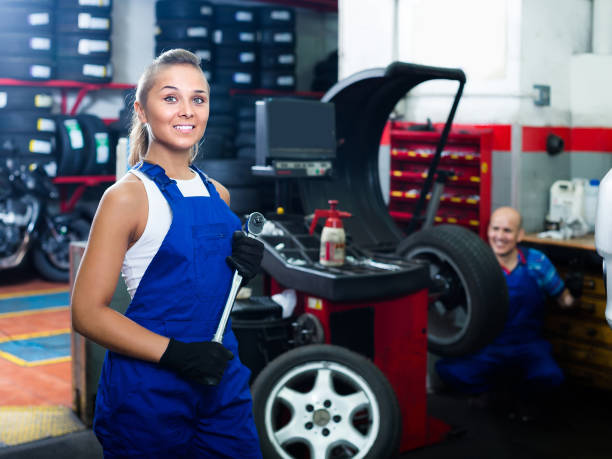 istock female technician standing with wheel balancing machinery at auto workshop 950317586