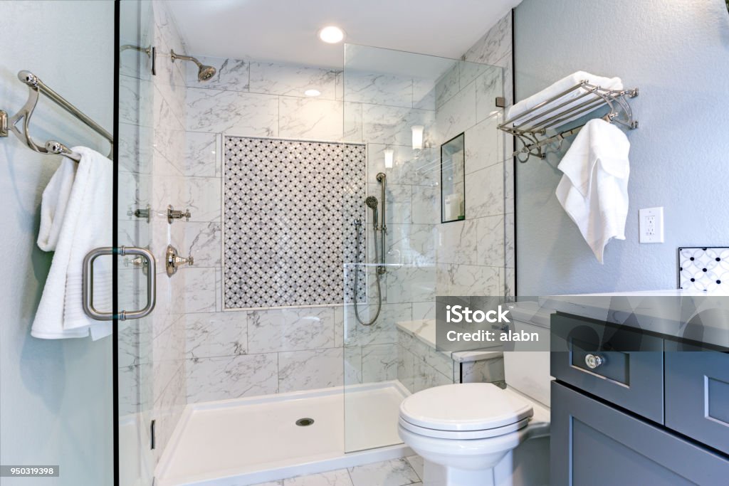 New blue bathroom design with Marble shower Surround New blue bathroom design with Marble shower Surround and mosaic accent tiles. Shower Stock Photo