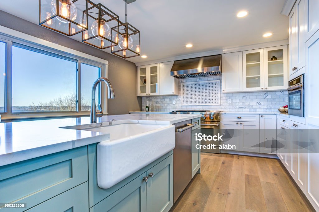 Beautiful kitchen room with green island and farm sink. Beautiful kitchen room with green island and farmhouse sink. Kitchen Stock Photo
