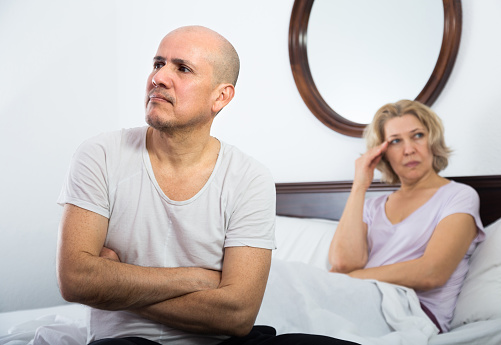Frustrated senior mature couple having quarrel in bedroom