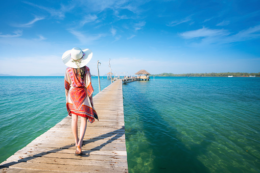 Asian lady walk in wooded bridge to harbor in Koh Mak, Mak and Kood island is travel place in Thailand, This image can use for Holiday, summer, beach, sea and travel concept