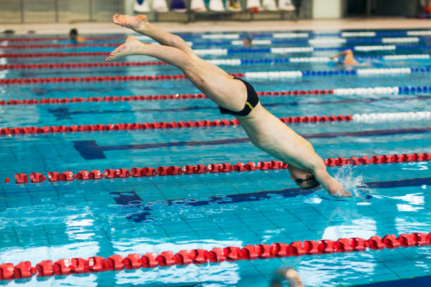 istock Swimmer Jumping Into Swimming Pool 950336716