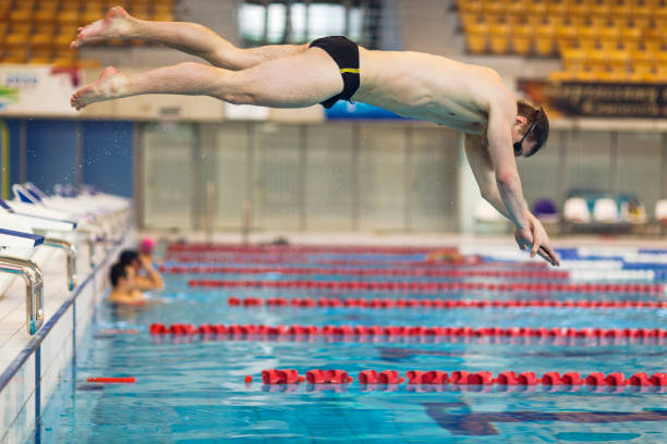 istock Swimmer Jumping Into Swimming Pool 950336718