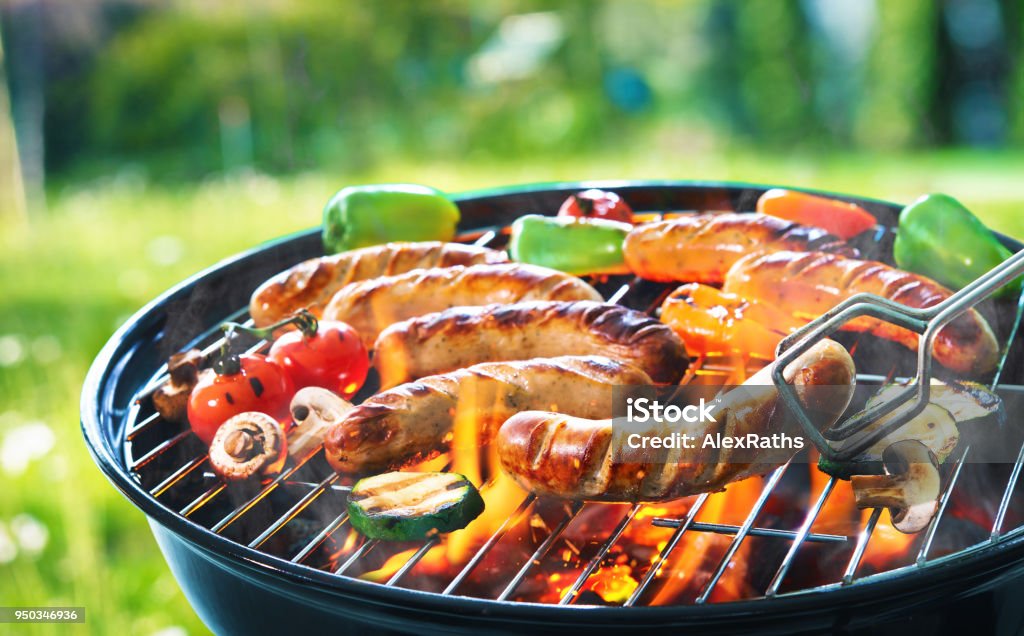 Grilled sausage on the flaming grill Grilled sausage on the picnic flaming grill Barbecue - Meal Stock Photo