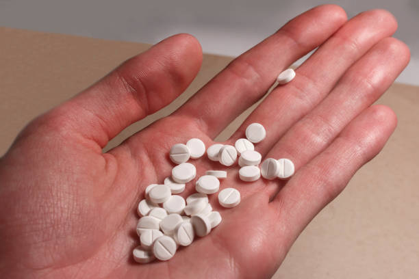 istock white pills in the male hand 950347442
