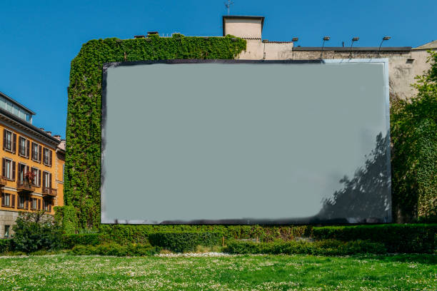 espace vierge de publicité sur le mur à côté d’herbe et de vignes. - billboard bill city advertise photos et images de collection