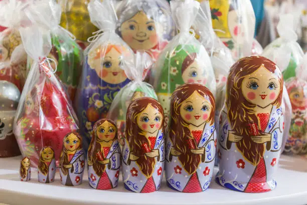 Photo of Matryoshka at souvenir market shop. Different colors Russian dolls