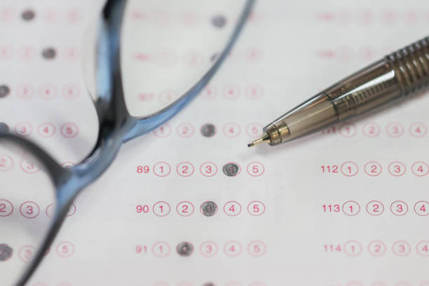 concept de test de l’éducation : forme optique de test standardisé avec stylo noir, boursouflé de réponses près de verres sur la feuille de réponses à la salle de classe à l’université, mise au point sélective - bubbled photos et images de collection