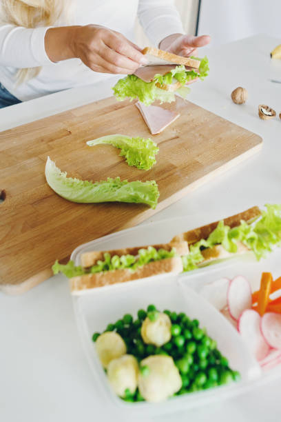 istock mom preparing school lunch for childrens in home kitchen 950356104