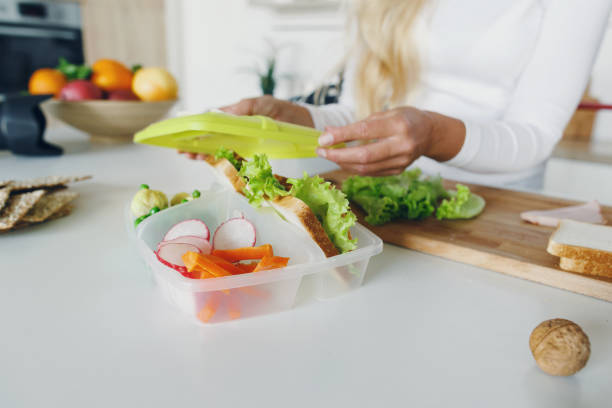 家庭の台所で子供の給食を準備する母親 - child human hand sandwich lunch box ストックフォトと画像