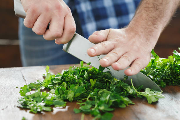 istock Close up man is cooking parsley on wooden table 950357064