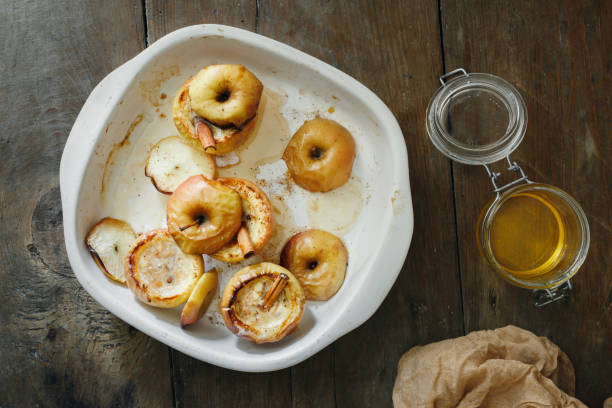 istock Top view apples topped with nuts, honey and cinnamon in baking dish on wooden table 950359600