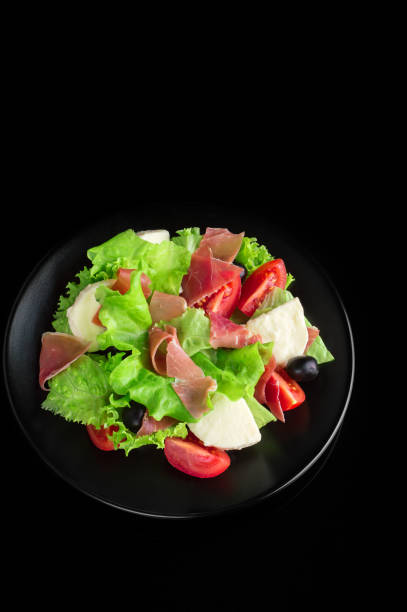 istock Fresh tasty salad on a glossy black background 950364046