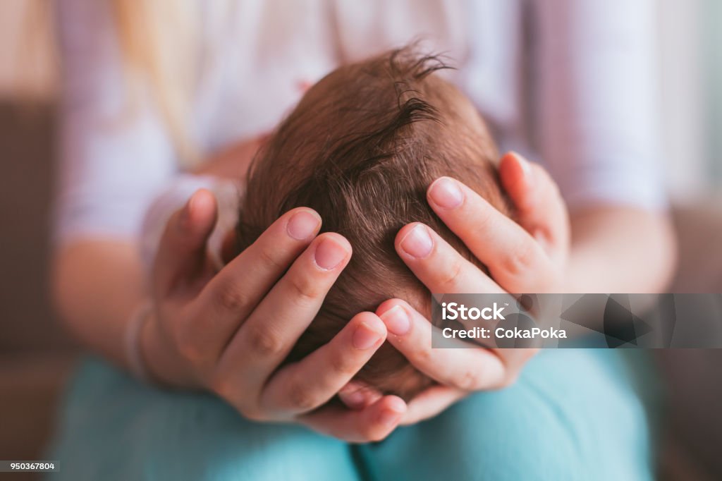 Mother holding newborn baby boy Mother holding newborn baby boy on her knees, closeup Baby - Human Age Stock Photo