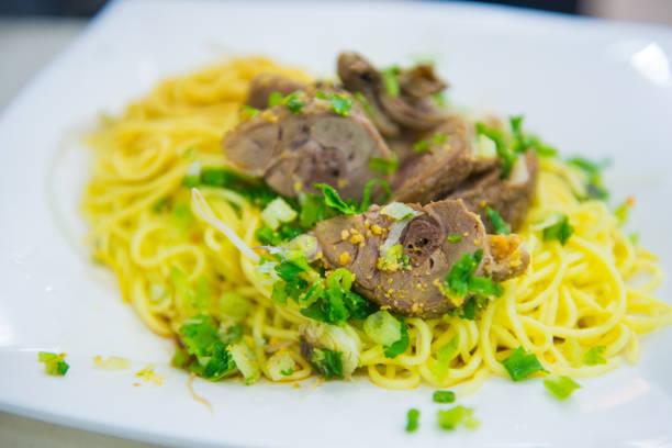 Typical Siwss gourmet-meal with meat, pasta and vegetables on a stylish place cover with white table-cloth