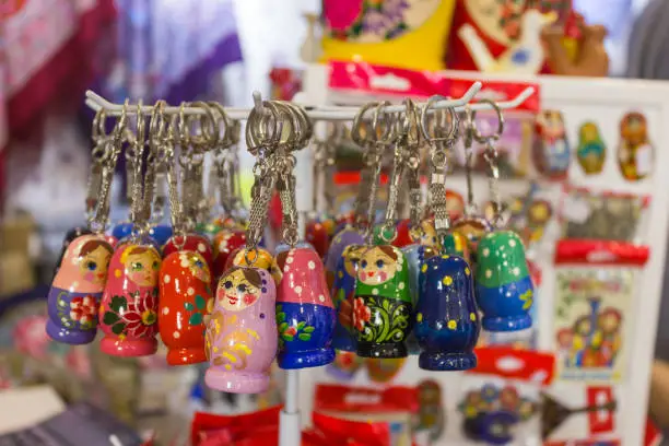 Photo of Matryoshka at souvenir market shop. Different colors Russian dolls