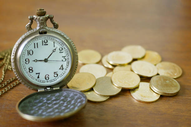 istock vintage golden pocket watch with stack  on wood table background 950370758