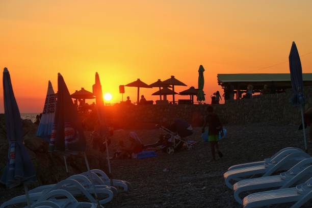 ビーチ バー夕日の光でドブラー ヴォーダ ビーチに。モンテネグロは、ヨーロッパ。 - bar chairs ストックフォトと画像