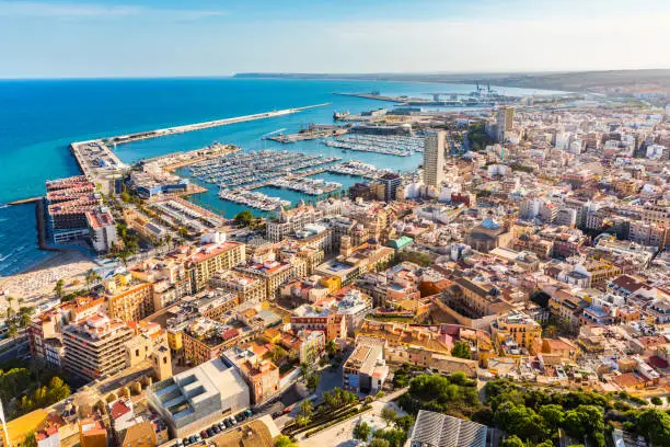 Alicante city panoramic aerial view with seaside, harbour and houses. Spanish city with beautiful beach. Travel and holidays concepts with a popular European summer destination.