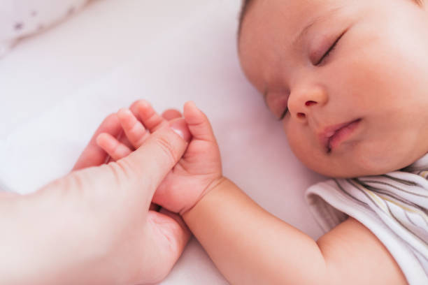 istock mother holding a baby hand 950371716