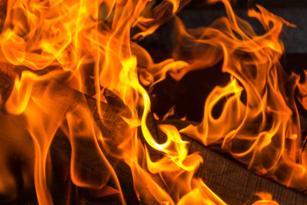 istock Bright fire flame orange tongues absorb firewood close-up 950372142