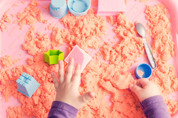 istock The hands of a child playing with kinetic sand 950372810