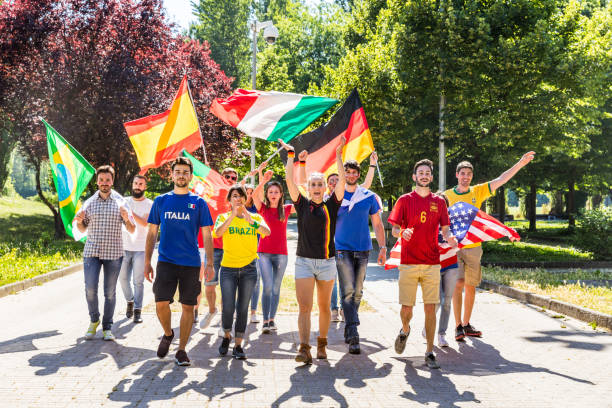 Happy fans supporters from different countries walking and chanting together Happy supporters from different countries walking and chanting together. Fans from England, USA, Brazil, Spain, Portugal and other countries enjoying sport together. Respect and fair play concepts international match stock pictures, royalty-free photos & images