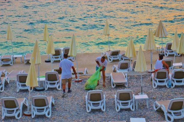 男性は、ドブラー voda のモンテネグロのビーチをクリーンアップします。 - bar chairs ストックフォトと画像