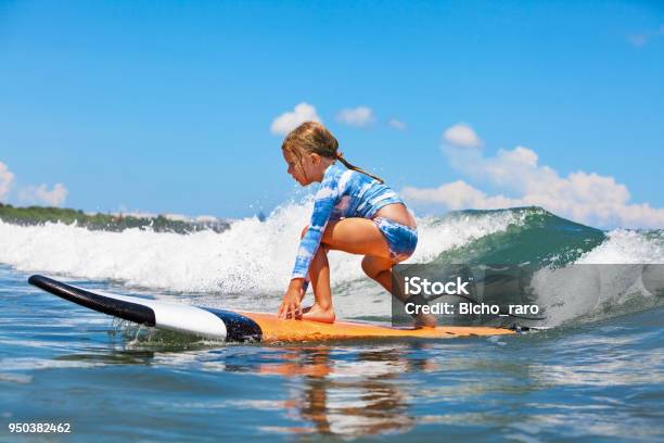 Young Surfer Rides On Surfboard With Fun On Sea Waves Stock Photo - Download Image Now