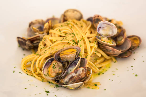 un piatto tipico con frutti di mare della tradizione balneare italiana - linguini foto e immagini stock