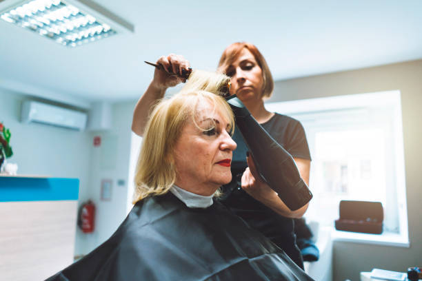 Haidresser drying her customer's hair in hair salon