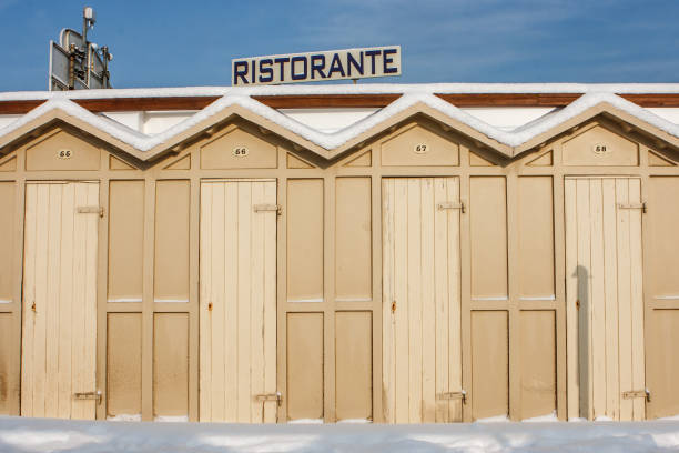 "cabine" (cabanas de praia) coberto de neve em riccione, emilia romagna, itália. assine dizendo "ristorante" (restaurante) sobre o fundo. - snow horizon winter shed - fotografias e filmes do acervo