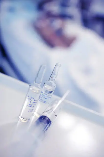 Drug vials and syringe at the patient bedside in the hospital.