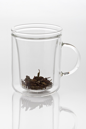 some leaf of white tea in a glass mug