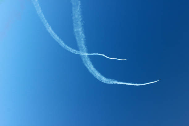 istock Curves white lines drown by airplane on the blue sky background horizontal view. 950419224