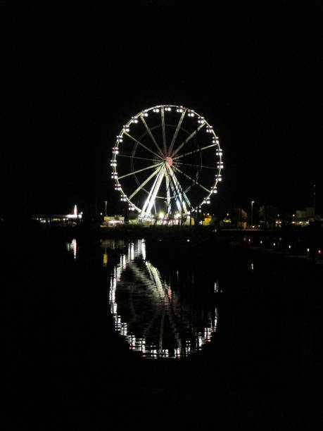 Italy, Emilia-Romagna, Rimini. Ferris wheel on black background, vertical view Night