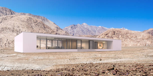 istock 3D rendering of modern architecture with warm interior lighting and desert mountain atmosphere on dirt gravel hill background,Concept of minimal design architectural. 950422742