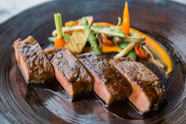 asado de buey de wagyu raro medio servido con salsa agridulce con vegetales al horno en placa de piedra. - round of beef fotografías e imágenes de stock