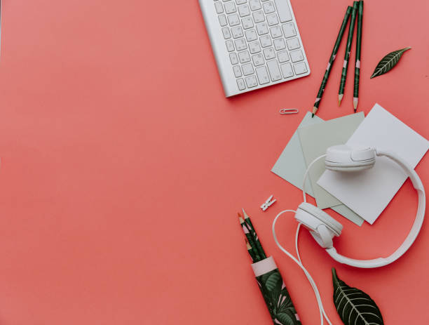 Creative workspace with headphones, keyboard and tropical leaves. Top view, copy space. Flat lay