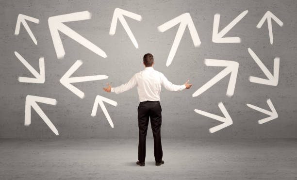 istock Confused salesman with arrows on wall 950437314
