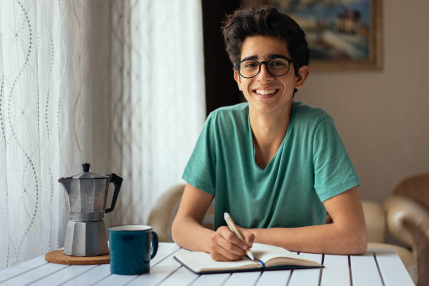 Teenage boy studying at desk Teenage boy studying at desk nerd teenager stock pictures, royalty-free photos & images